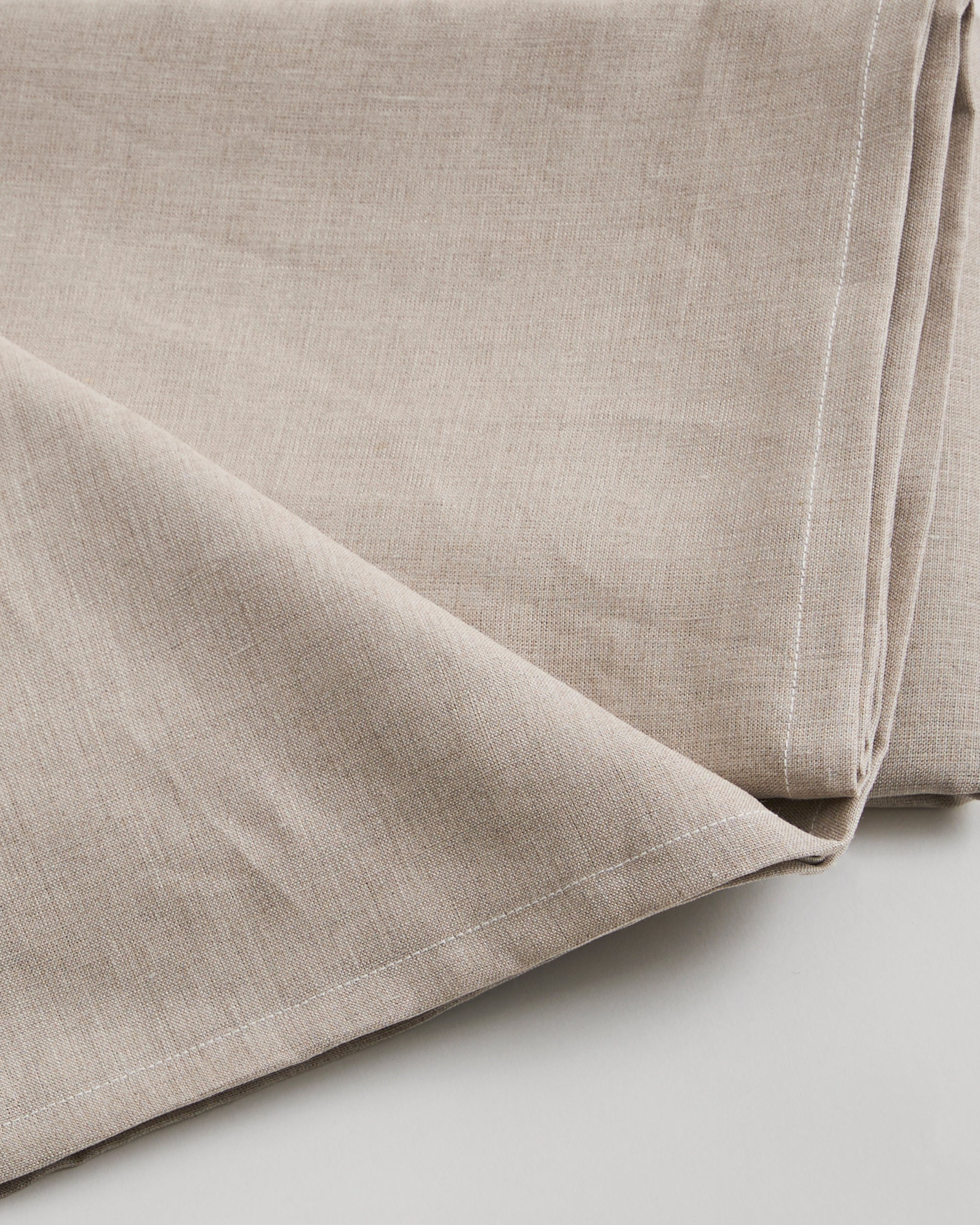 Close-up of unbleached linen sheet by Iwata on a light gray background
