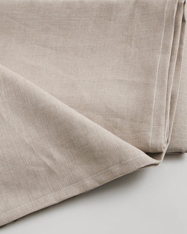 Close-up of unbleached linen sheet by Iwata on a light gray background