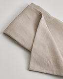 Close-up of unbleached linen flat sheet by Iwata on a light gray background