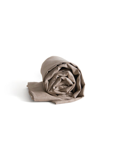 Rolled-up unbleached linen duvet cover by iwata on a white 