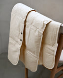 beige down feather shawl by Iwata draped on a chair