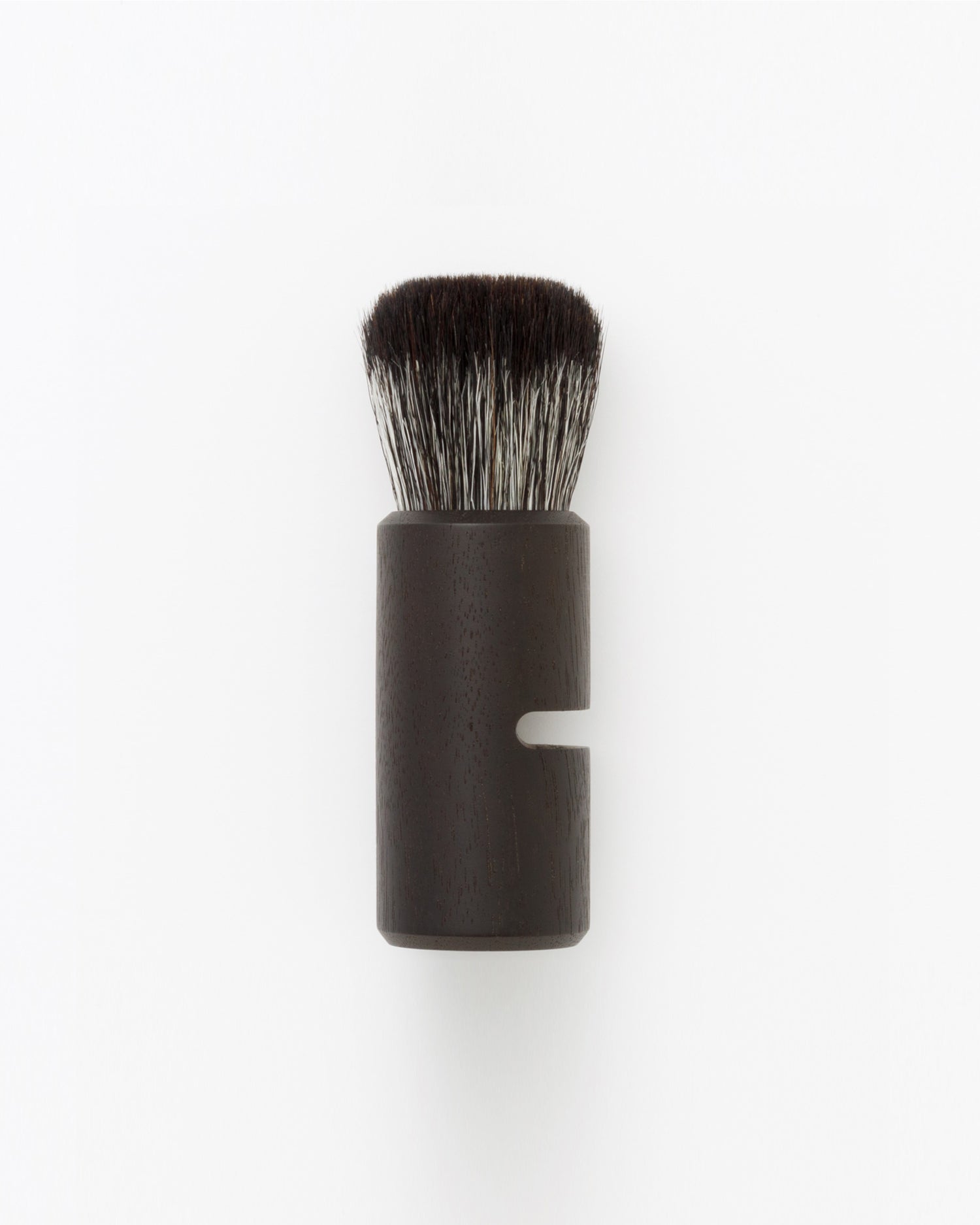 Silhouetted image of hard Jiva face cleansing and shaving series walnut, boar bristle, and goat hair brush by Shaquda against white-gray background. 