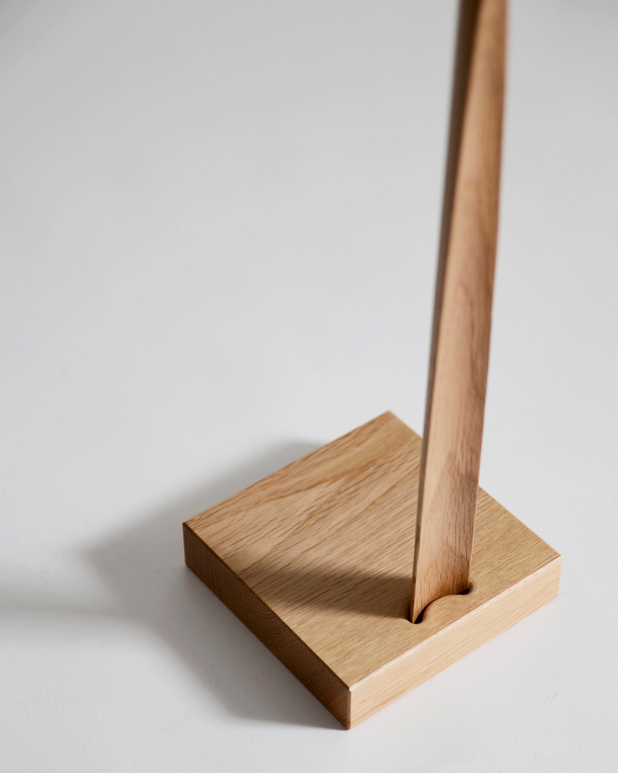 Up-close of wooden shoe horn with square base by Nalata Nalata and Kime on a gray background