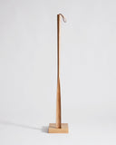 Wooden shoe horn with square base by Nalata Nalata and Kime on a gray background