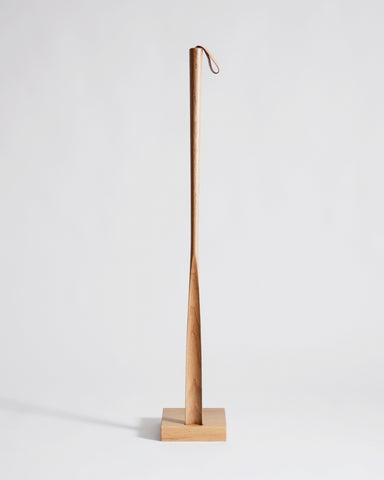 Wooden shoe horn with square base by Nalata Nalata and Kime on a gray background
