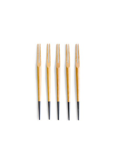 Five small two pronged bamboo forks by Kohchosai Kosuga with black ends in a row against a white background