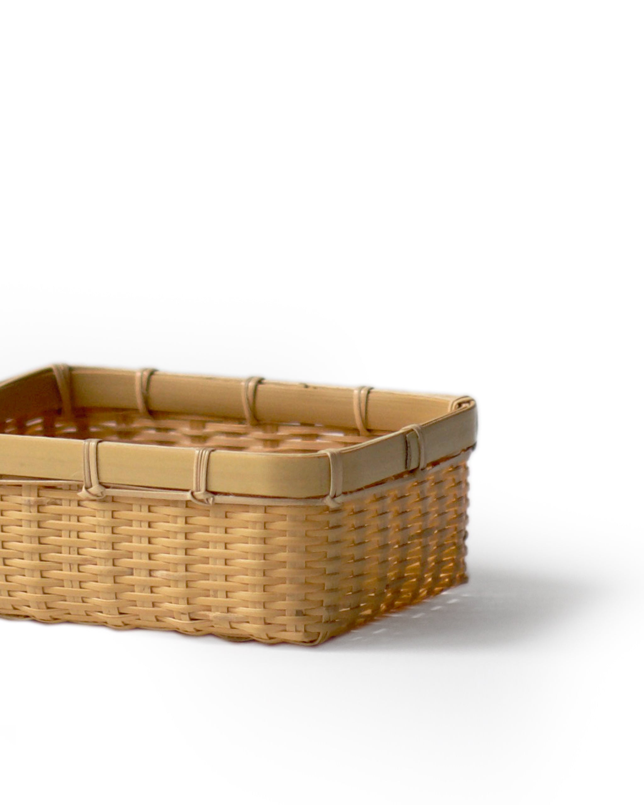 Cropped image of small woven rectangular basket by Kohchosai Kosuga against white background. 