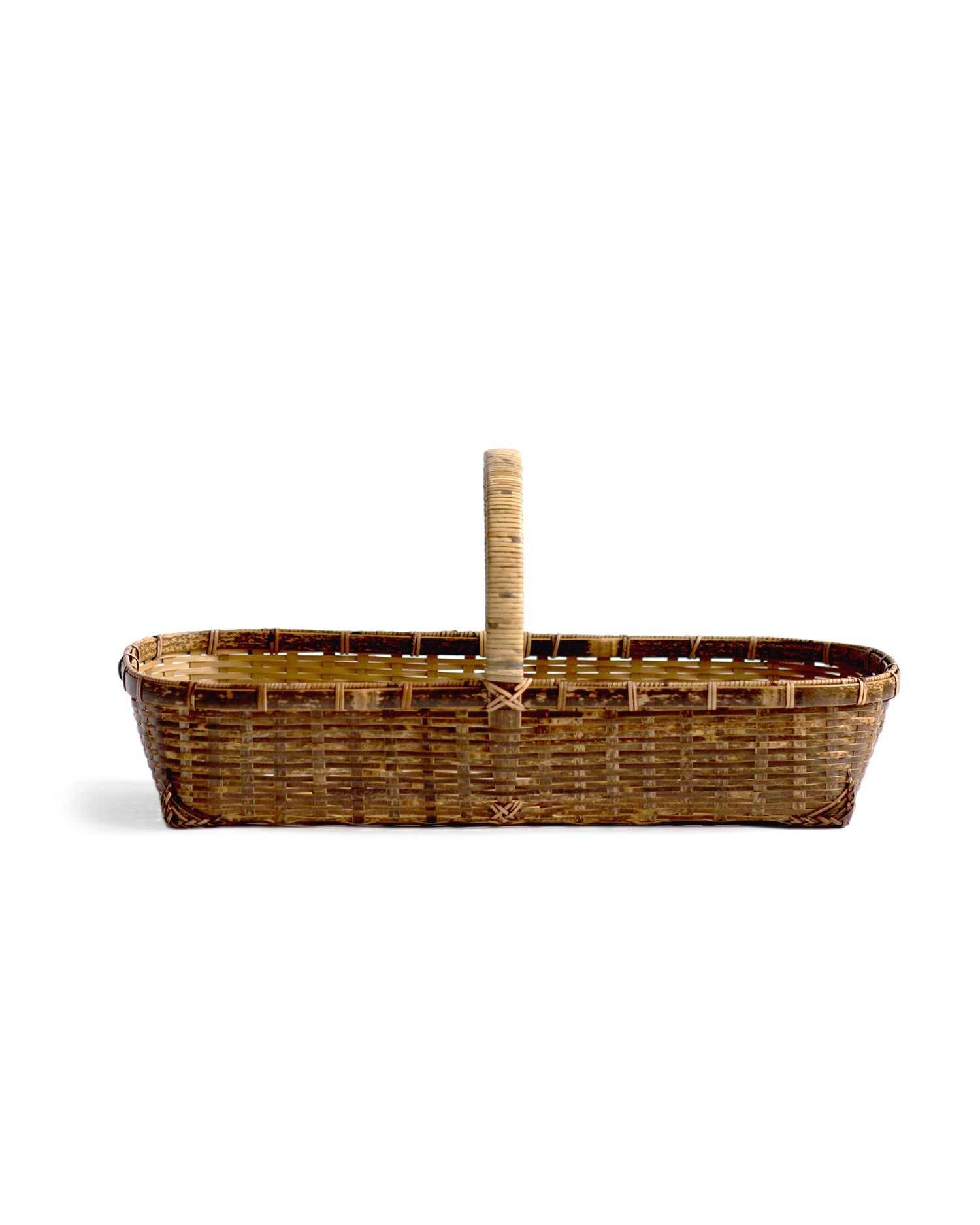 Silhouetted side image of long toradake bread basket with handle by Kohchosai Kosuga against white background.