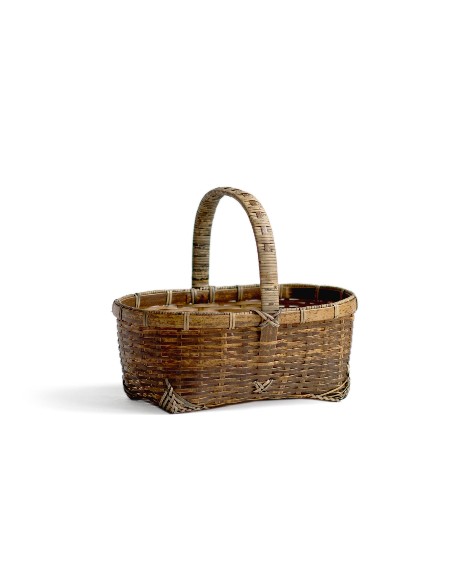 Silhouetted angled  image of small toradake bread basket with handle by Kohchosai Kosuga against white background.
