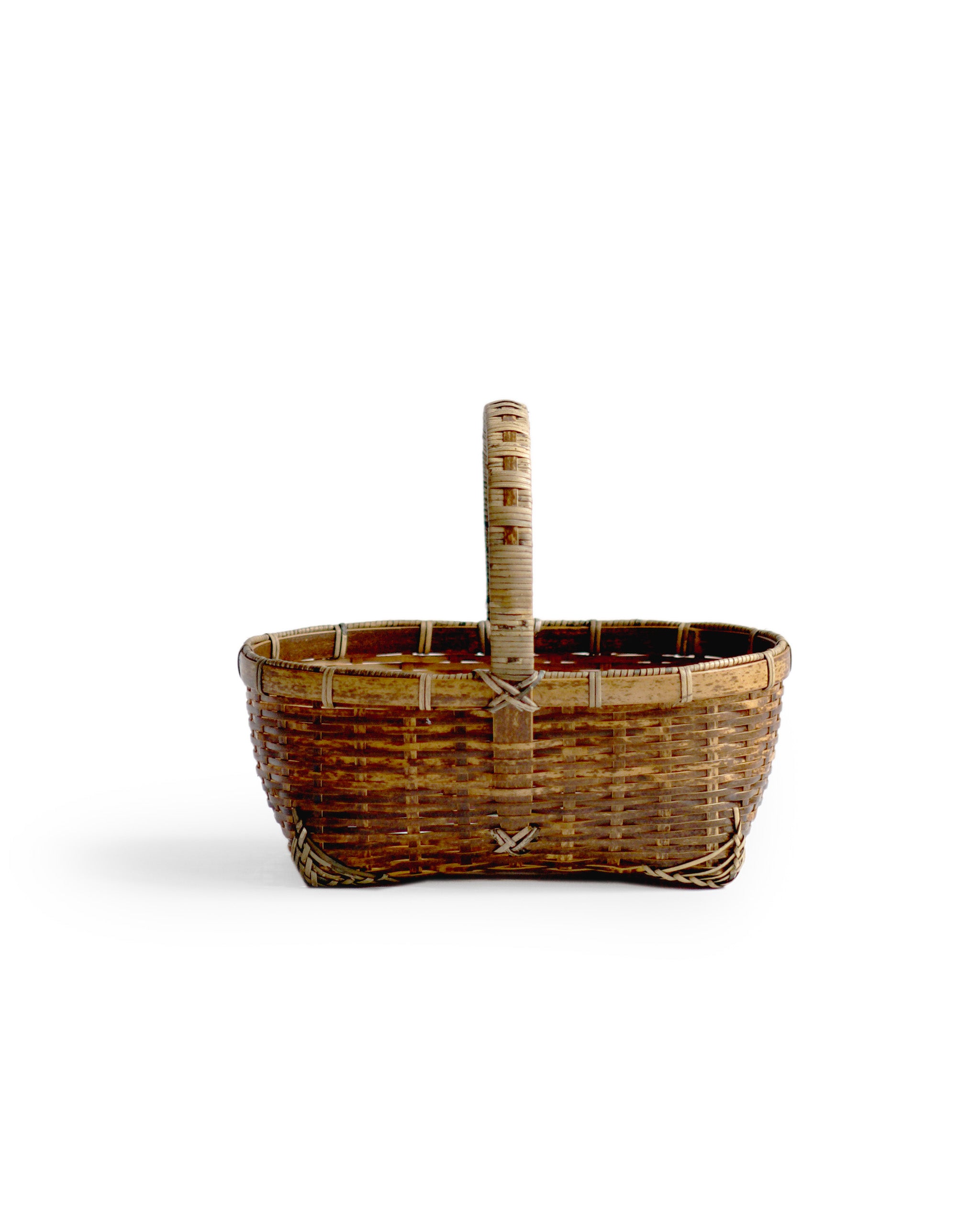 Silhouetted side image of small toradake bread basket with handle by Kohchosai Kosuga against white background.