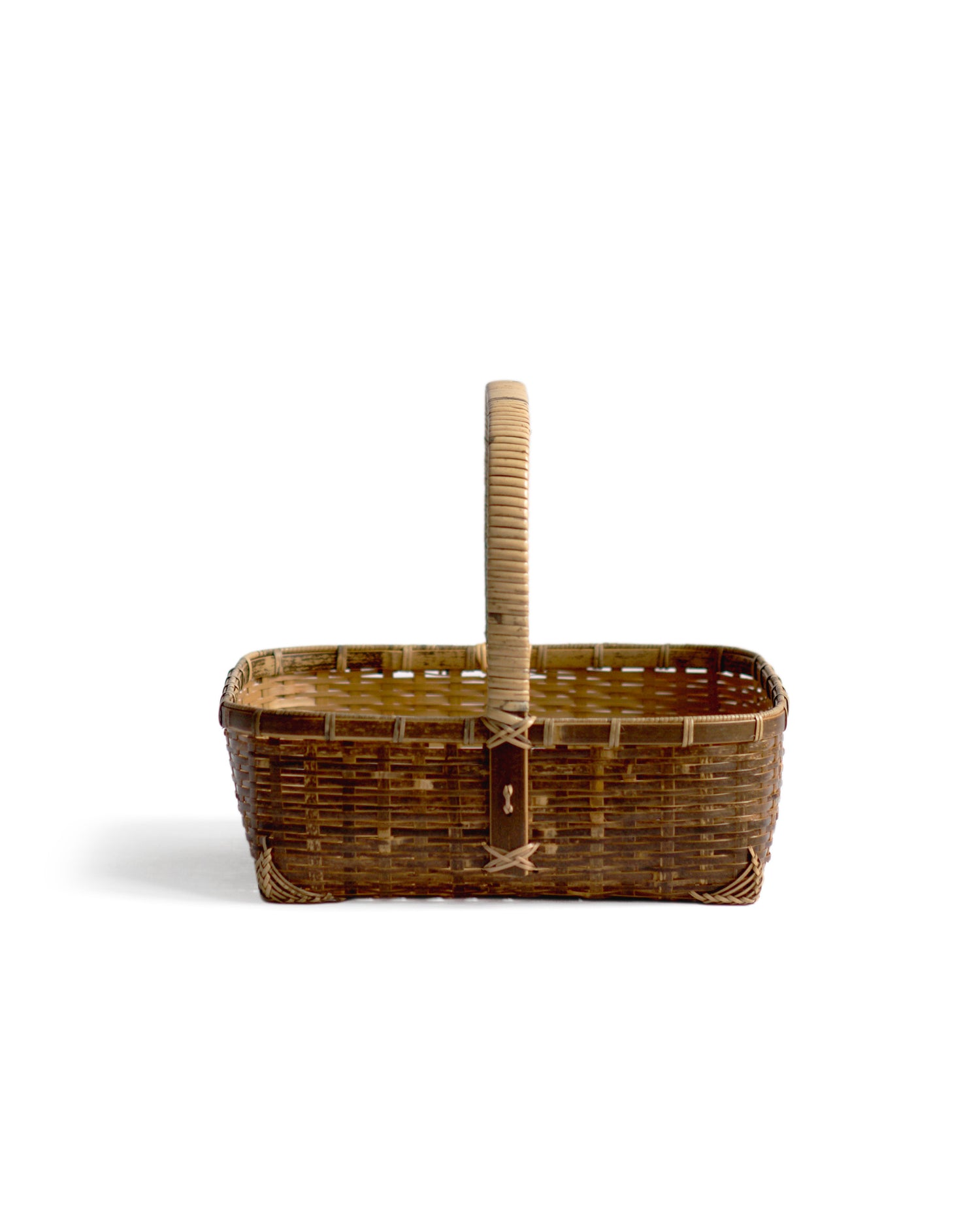 Silhouetted side image facing handle of square toradake bread basket with handle by Kohchosai Kosuga against white background.