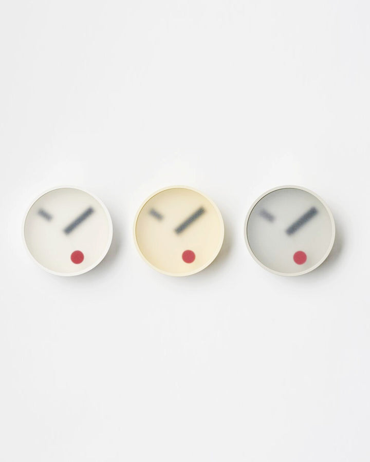 Front view of White, Yellow, and Gray Kehai Clocks by Koizumi studio against white-gray background. 