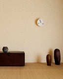 In situation image of Yellow Kehai Clock by Koizumi Studio on cream speckled wall.