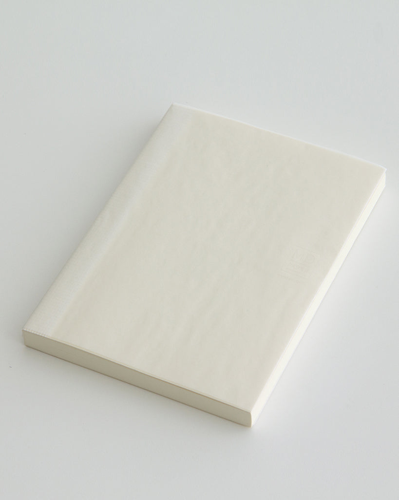 Angled silhouetted midori blank thick a5 notebook against white background.