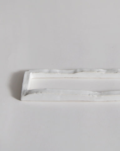 Up-close of white ceramic boundary sculpture by Masanobu Ando on a gray background