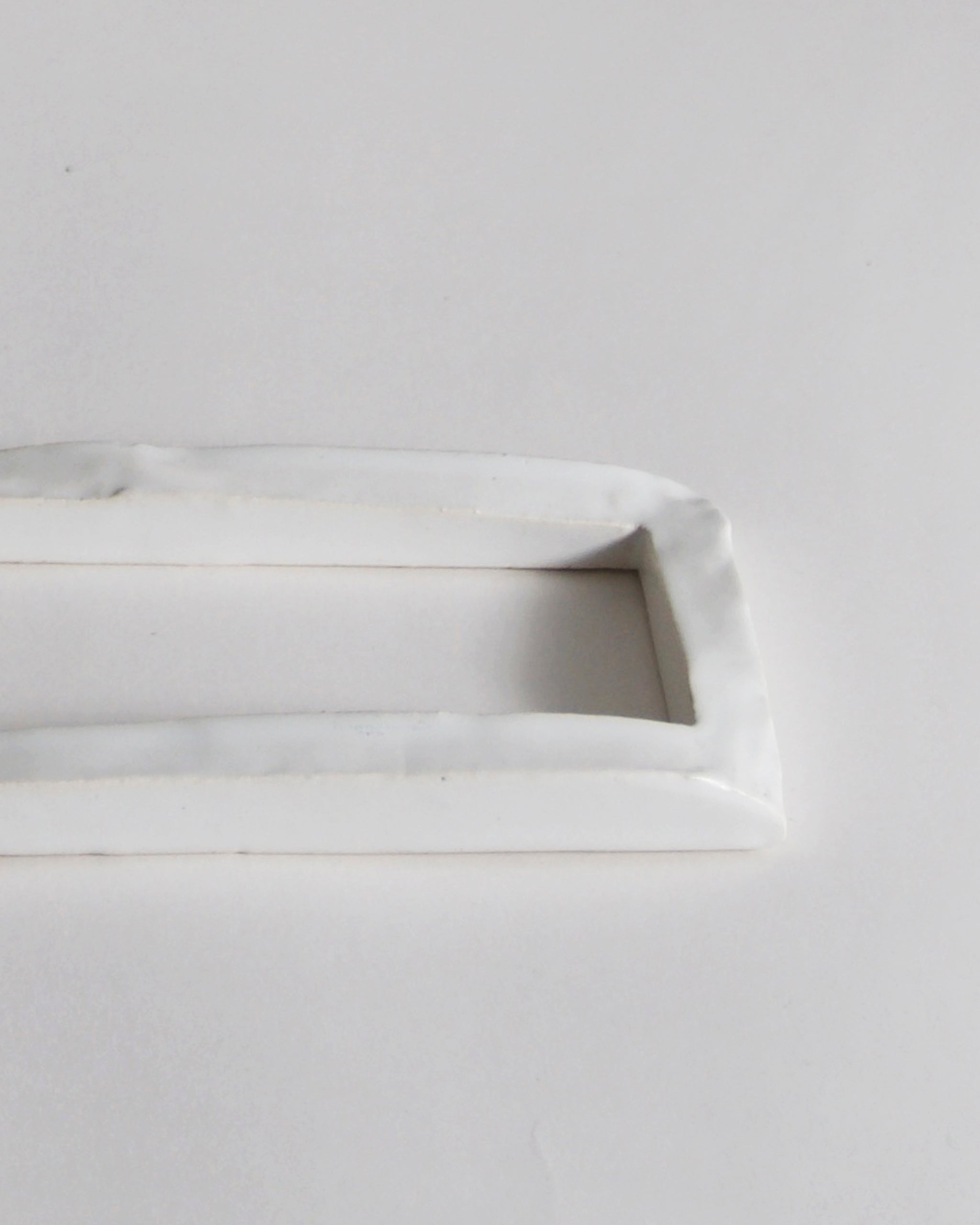 Up-close of white ceramic boundary sculpture by Masanobu Ando on a gray background