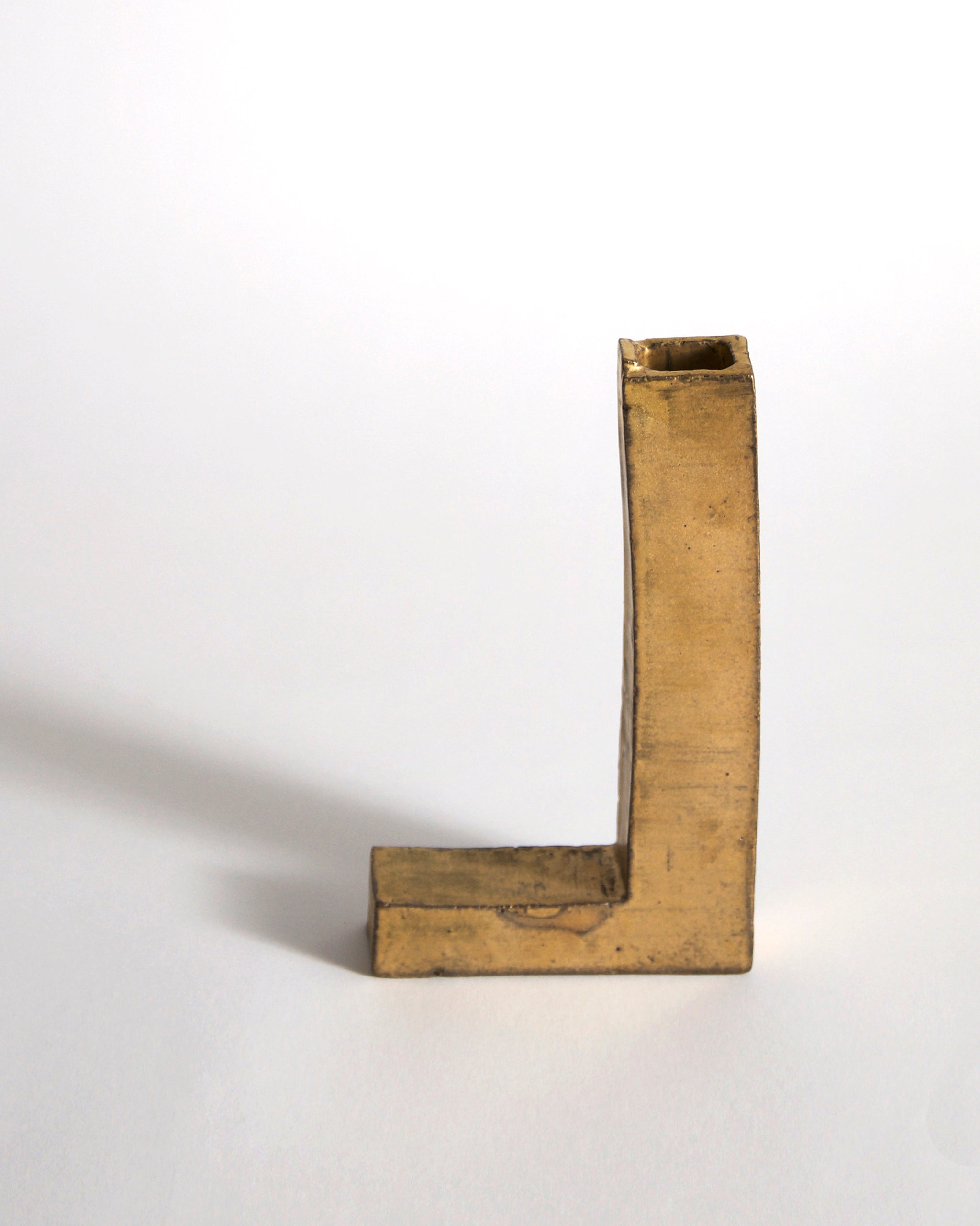 Gold Hanging Vase by Masanobu Ando on a gray background