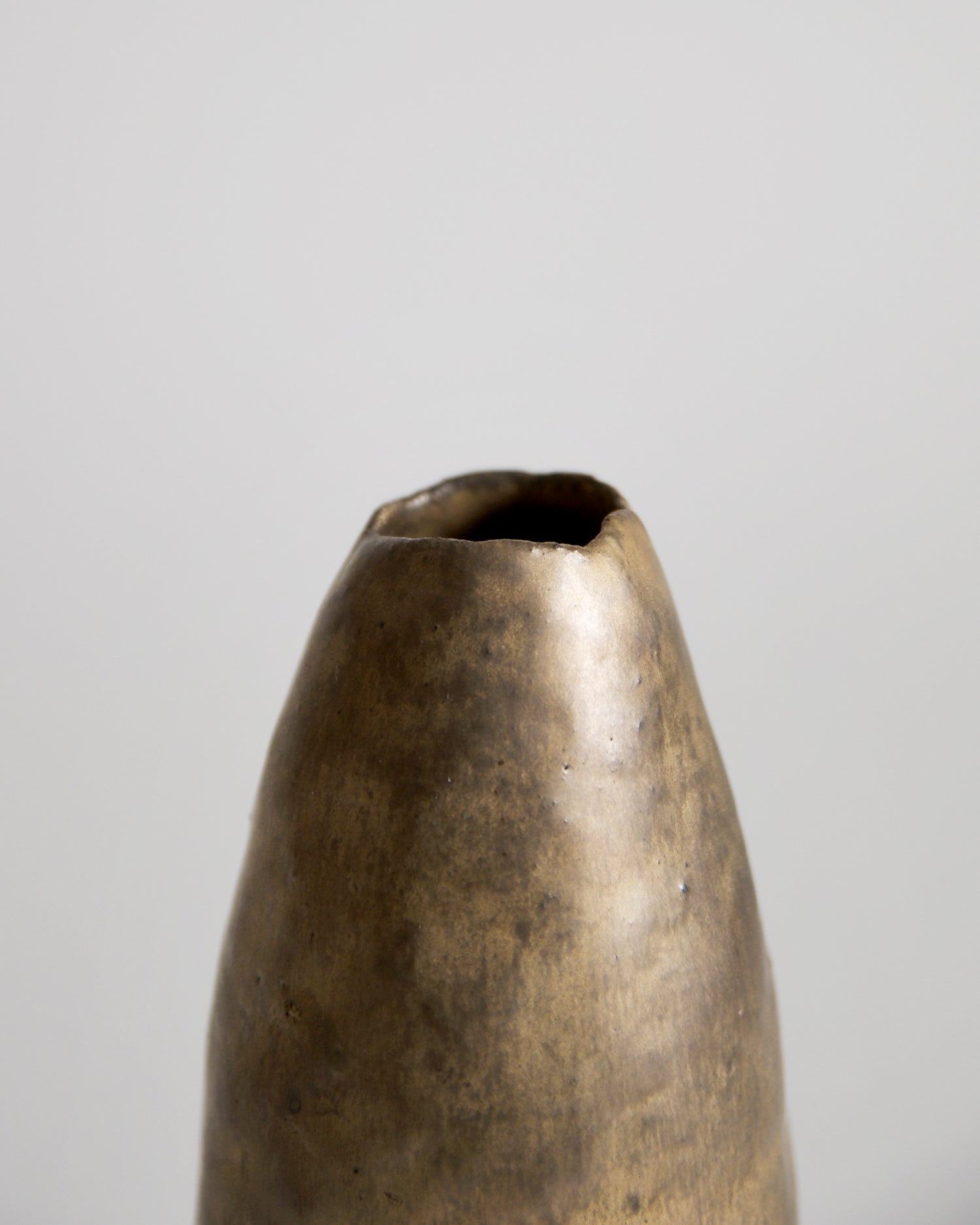 Up-close of top of Gold Vase by Masanobu Ando on a gray background