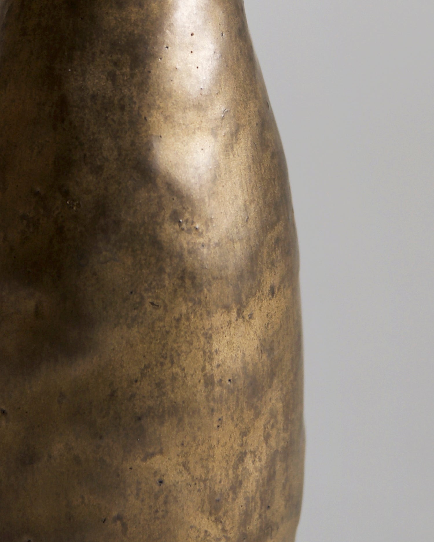 Up-close of side of Gold Vase by Masanobu Ando on a gray background