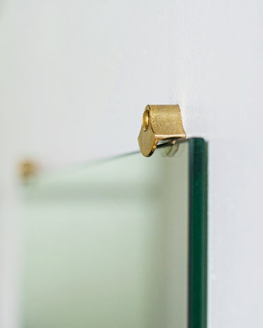 Side view of one matureware mirror stopper holding a square mirror.