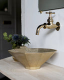 Matureware wash bowl installed on a oak wood countertop with a matching brass facet.