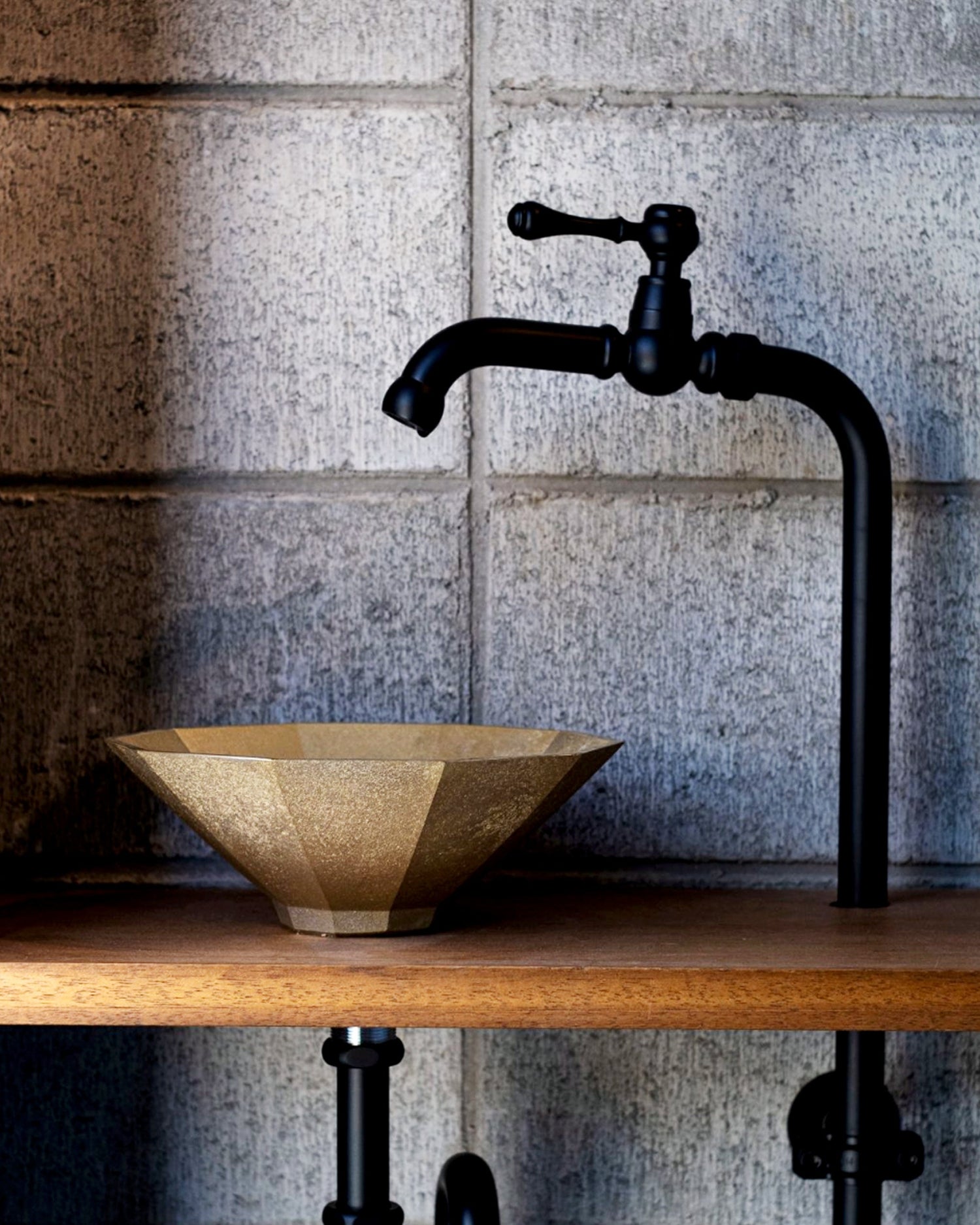 Matureware wash bowl is installed on a wooden countertop, connected to a black pipe and faucet. 