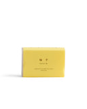 Yuzu Mutenka Sekken soap against a white backdrop. Packaging in a light yellow.