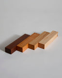 Wooden toothpick cases by Nalata Nalata and Tanno on a gray backdrop