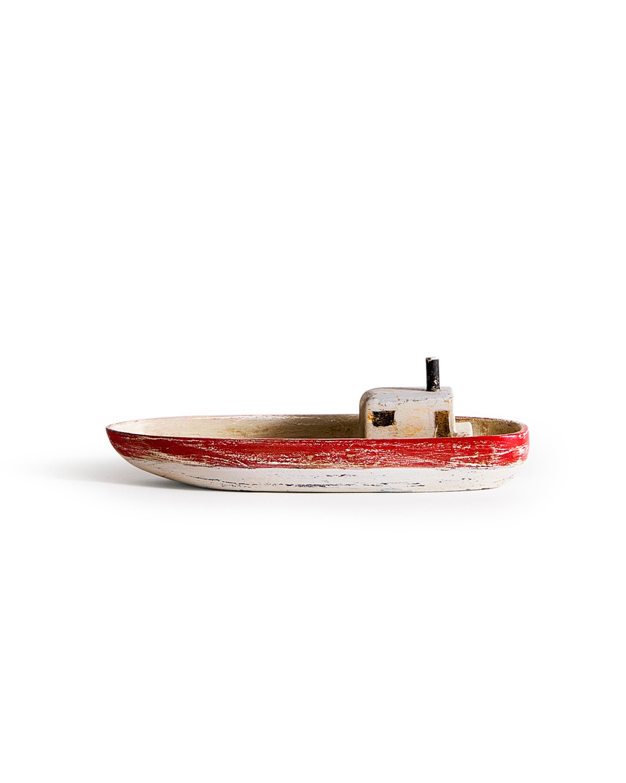 Small wooden boat with red,gray, and black paint by Ryuji Mitani on a white background