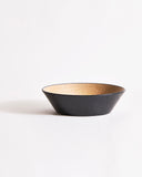 Wooden bowl by Ryuji Mitani with beige interior and black exterior on a gray background