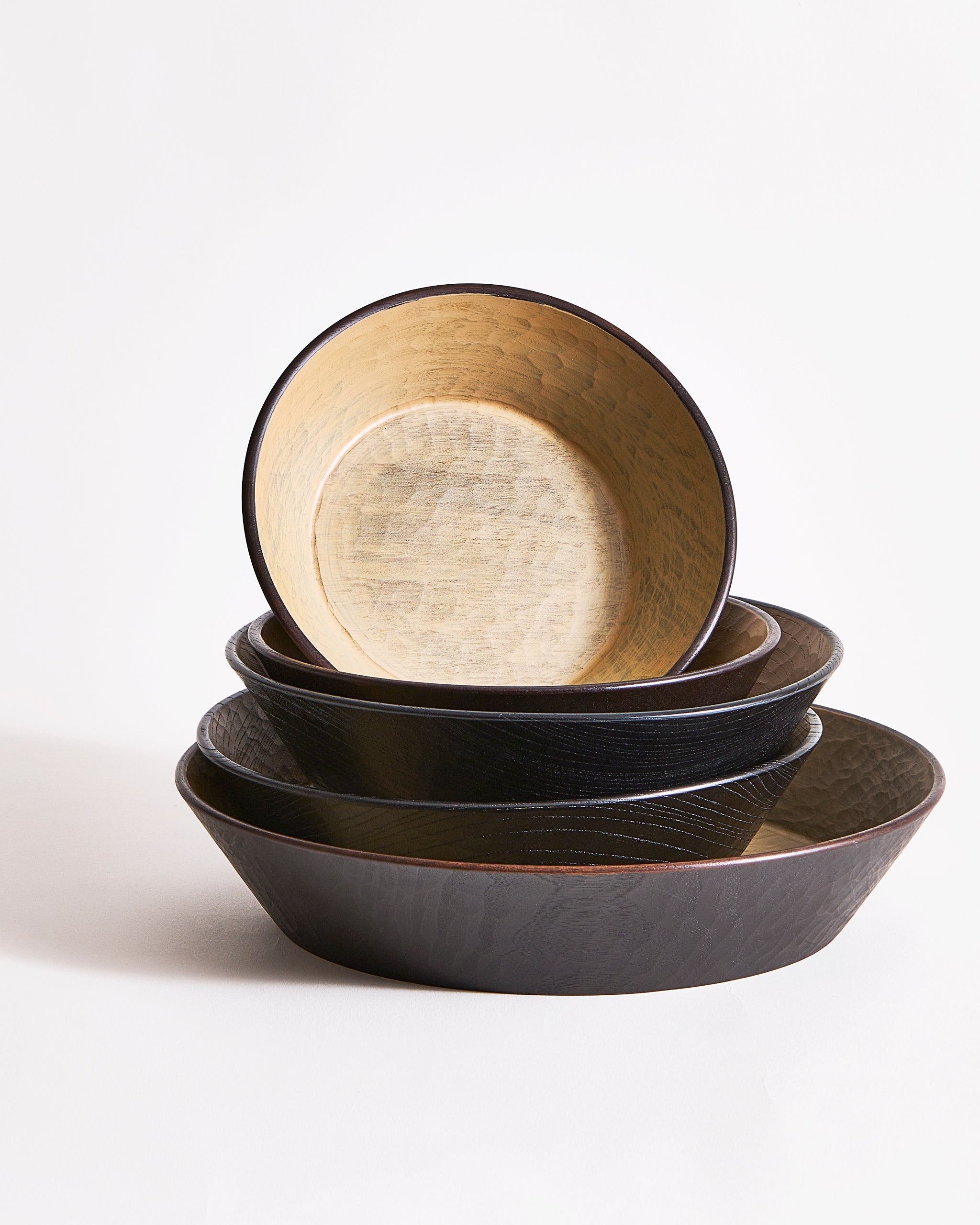 Wooden bowls stacked on top of each other with different sizes on a gray background