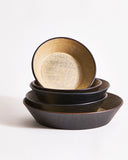 Wooden bowls stacked on top of each other with different sizes on a gray background