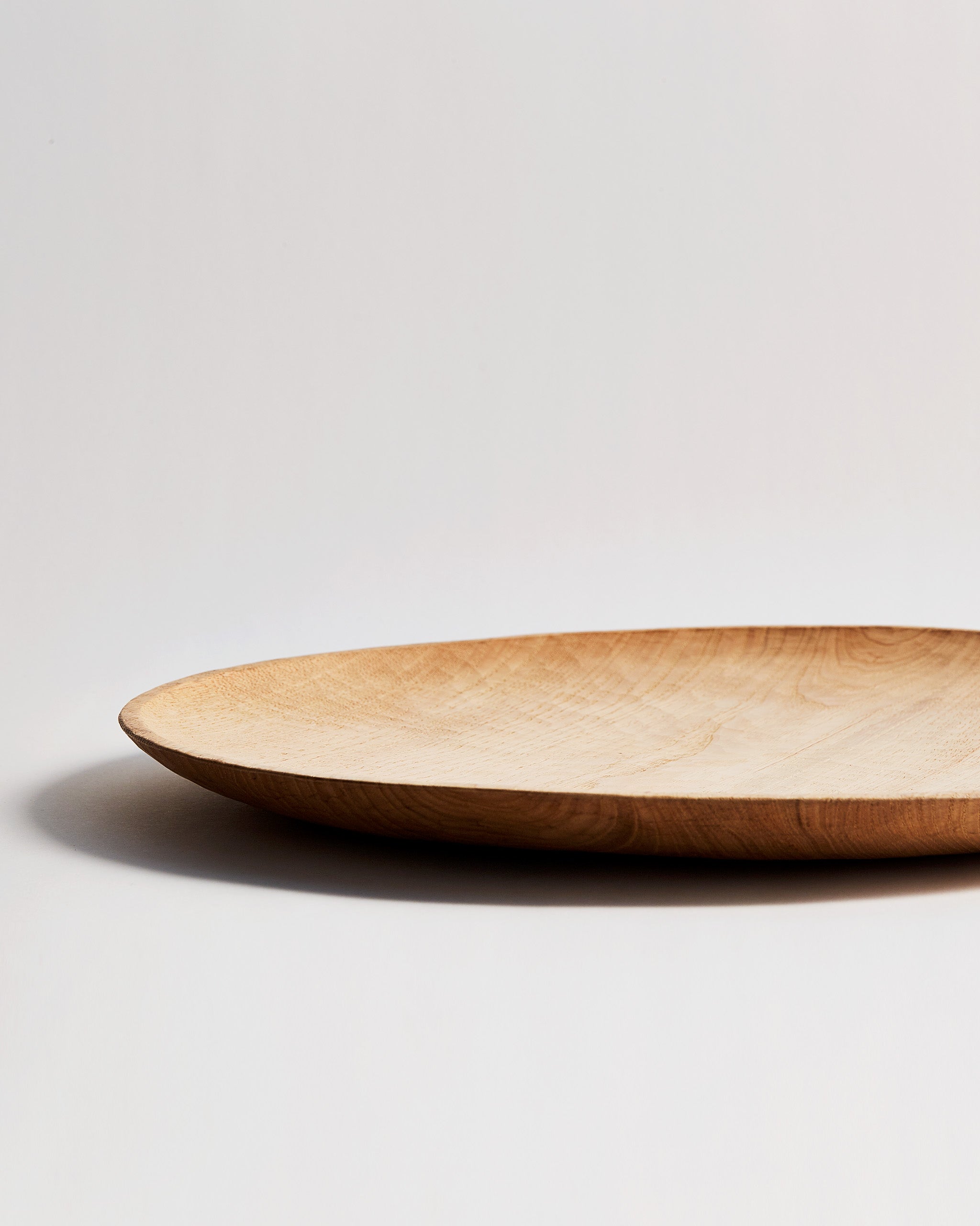 Cropped view of Large Chestnut Round Tray with Nano Glass Finish by Ryuji Mitani against white-gray background.