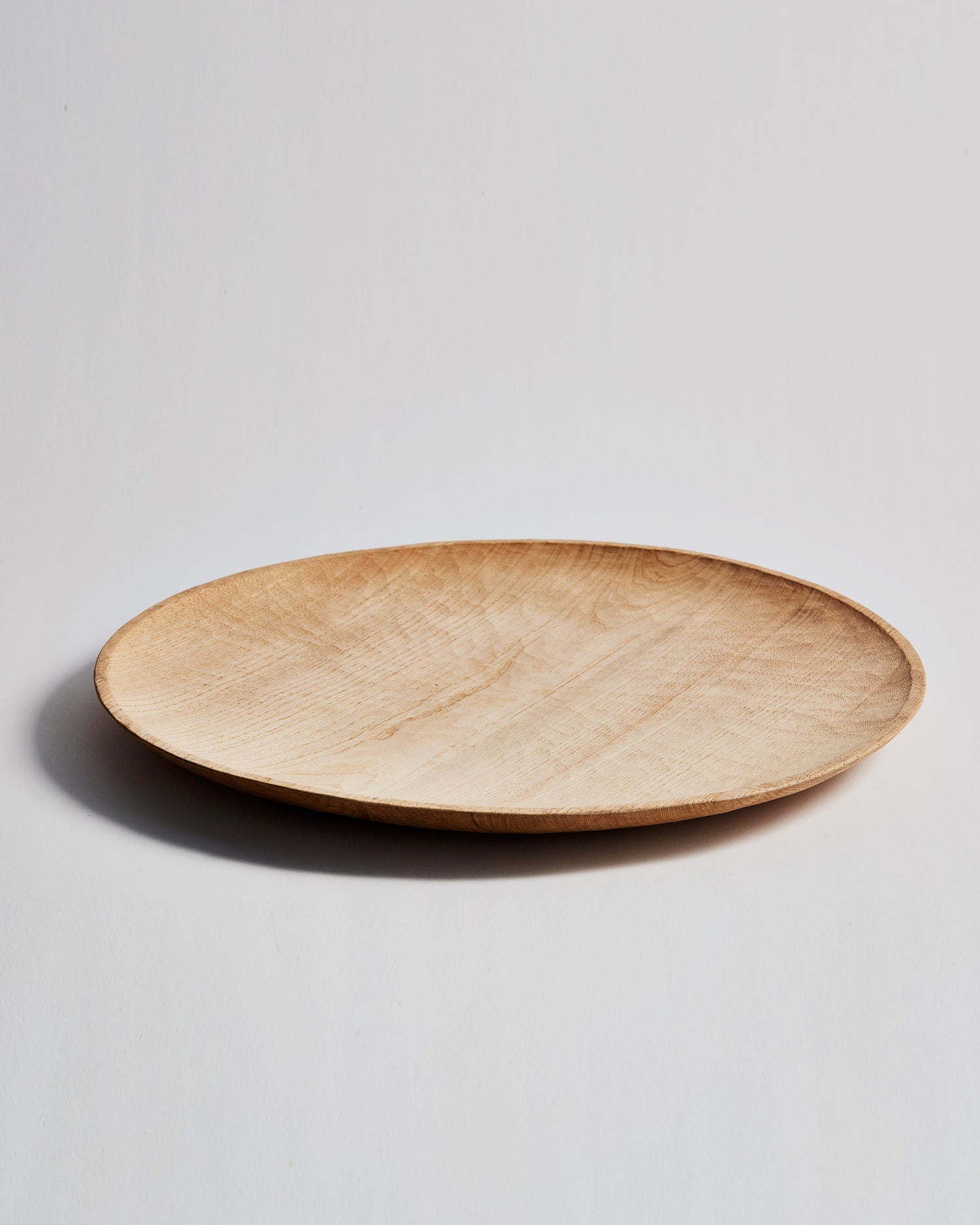 Front view of Large Chestnut Round Tray with Nano Glass Finish by Ryuji Mitani against white-gray background. 