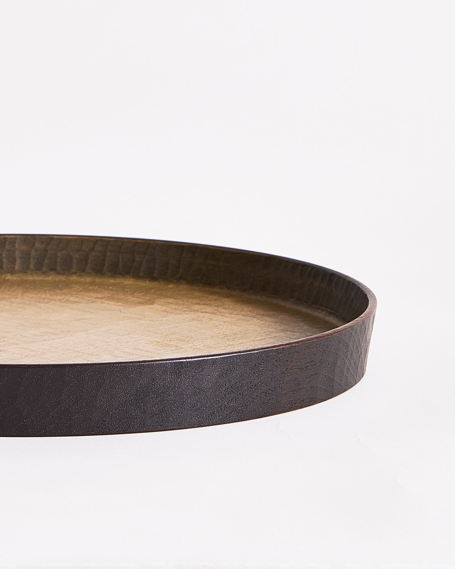 Up-close of right corner of wooden tray with black rim by Ryuji Mitani on a gray background