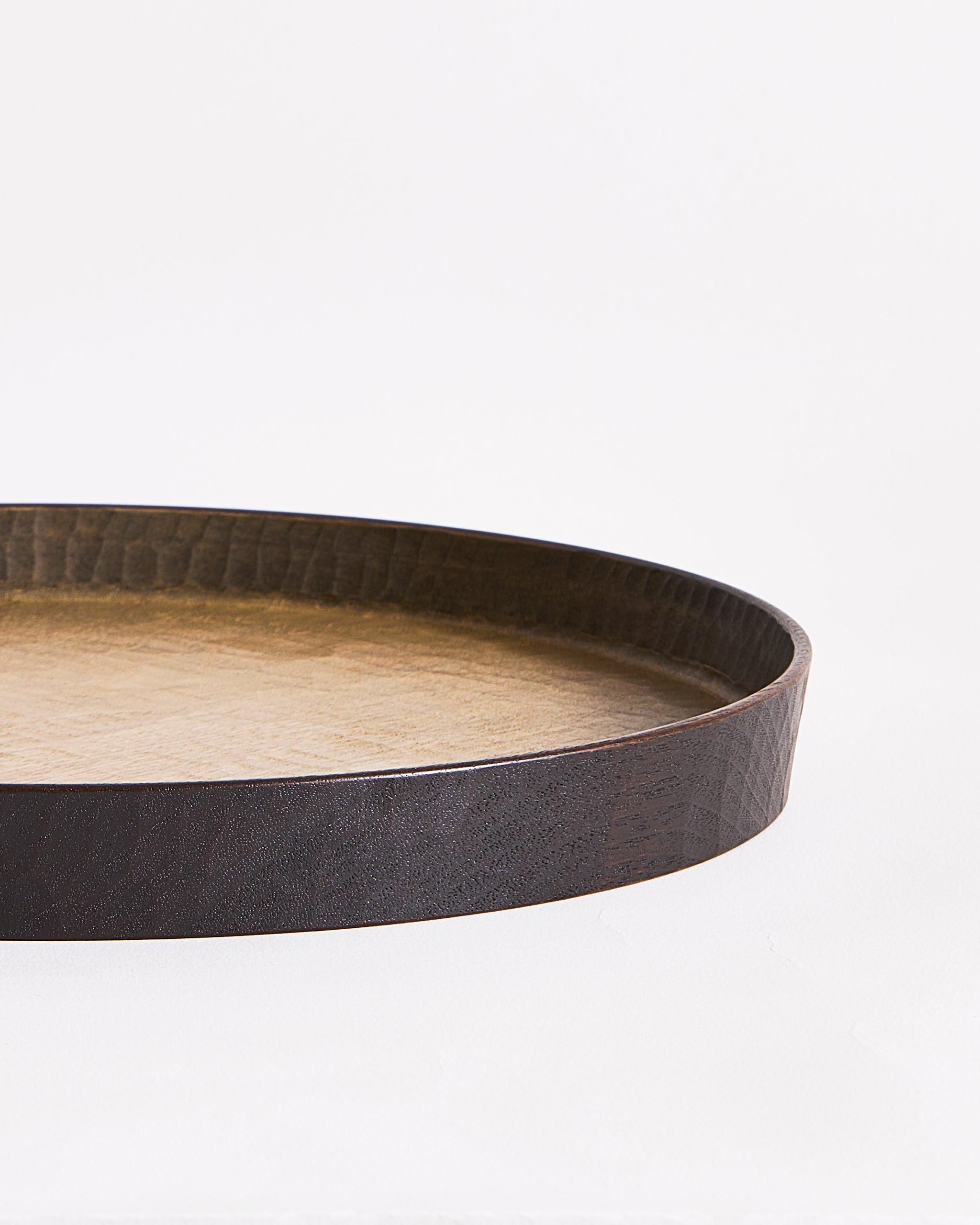 Up-close of right corner of wooden tray with black rim by Ryuji Mitani on a gray background
