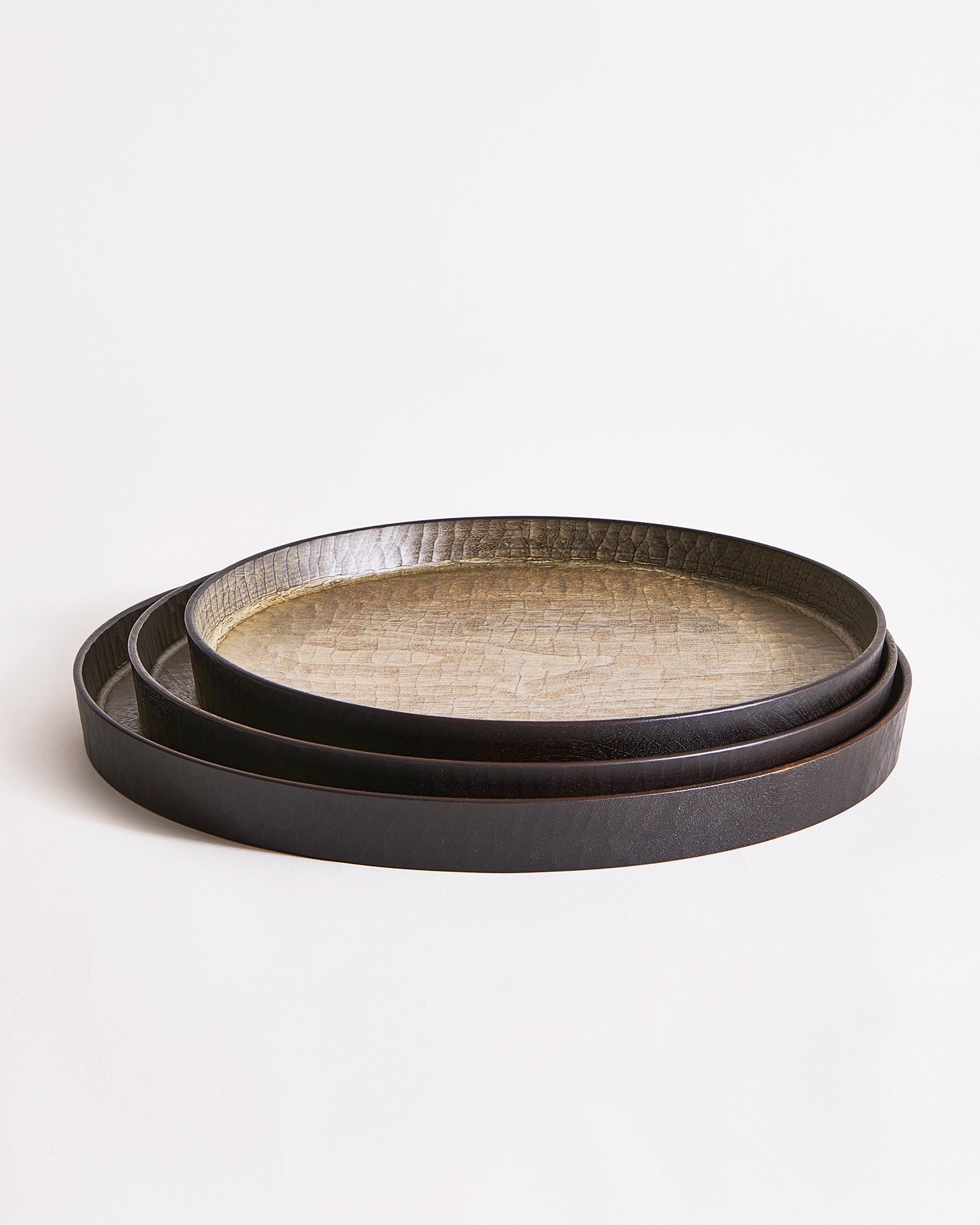 Stacked trays with textured surface by Ryuji Mitani on a light gray background