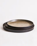 Stacked trays with textured surface by Ryuji Mitani on a light gray background