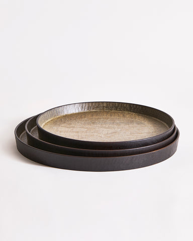 Stacked trays with textured surface by Ryuji Mitani on a light gray background
