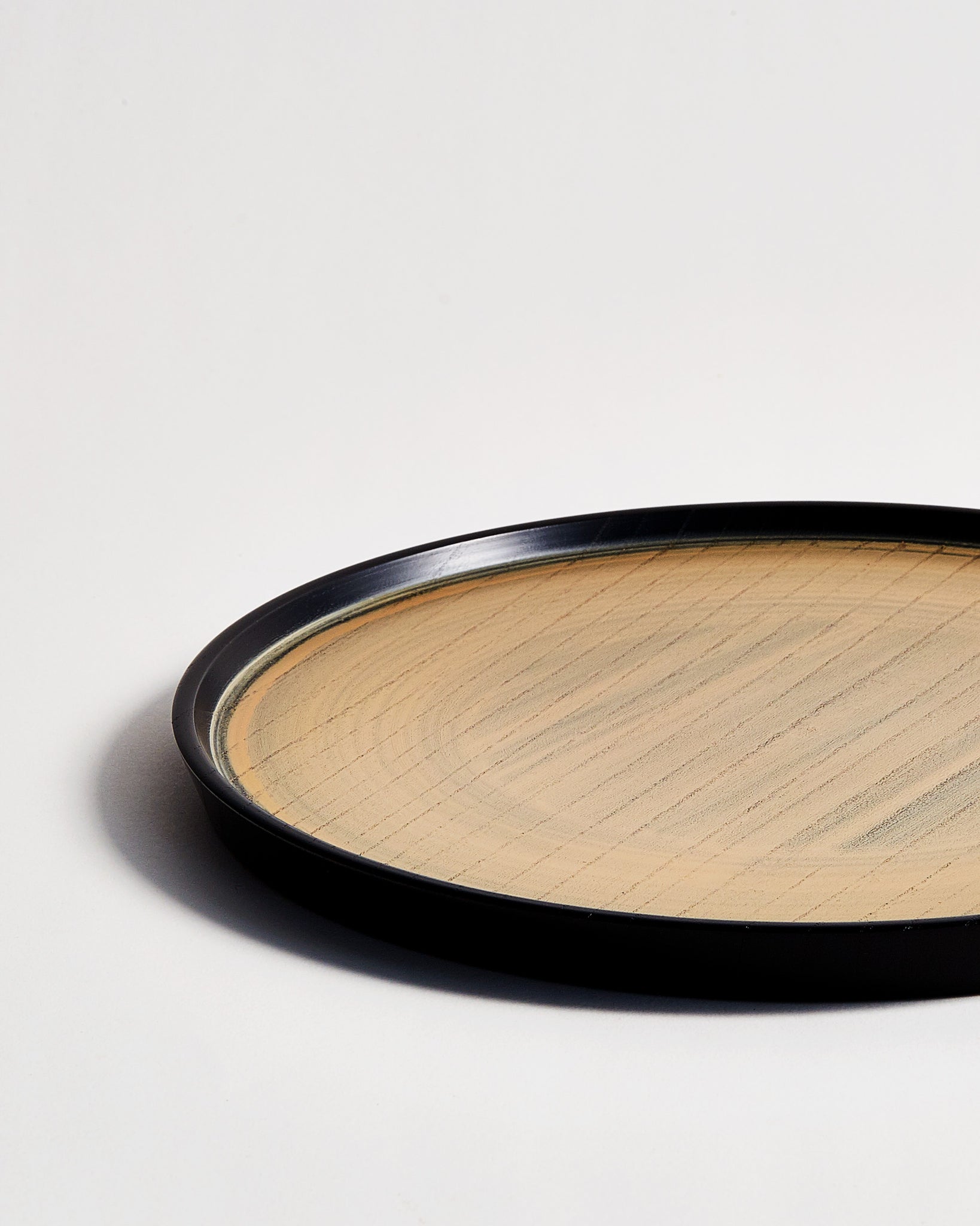 Cropped close-up image of Usuzumi Round Oak Tray by Ryuji Mitani against white-gray background. 