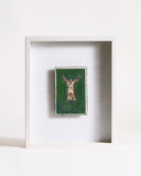Framed artwork of a person standing in a Y-shape on a green background