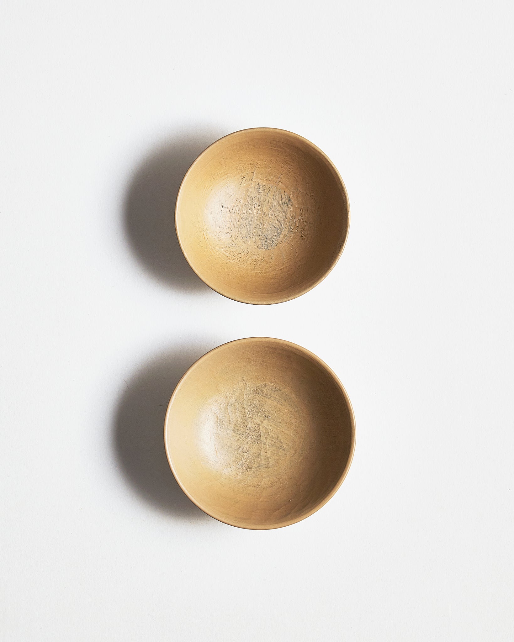 Top view of White Urushi Baby Bowl Set, vertically side-by-side, by Ryuji Mitani against white-gray background.