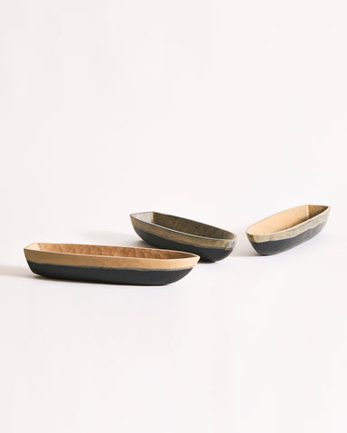 Three boat bowls with beige and black exteriors on a gray background