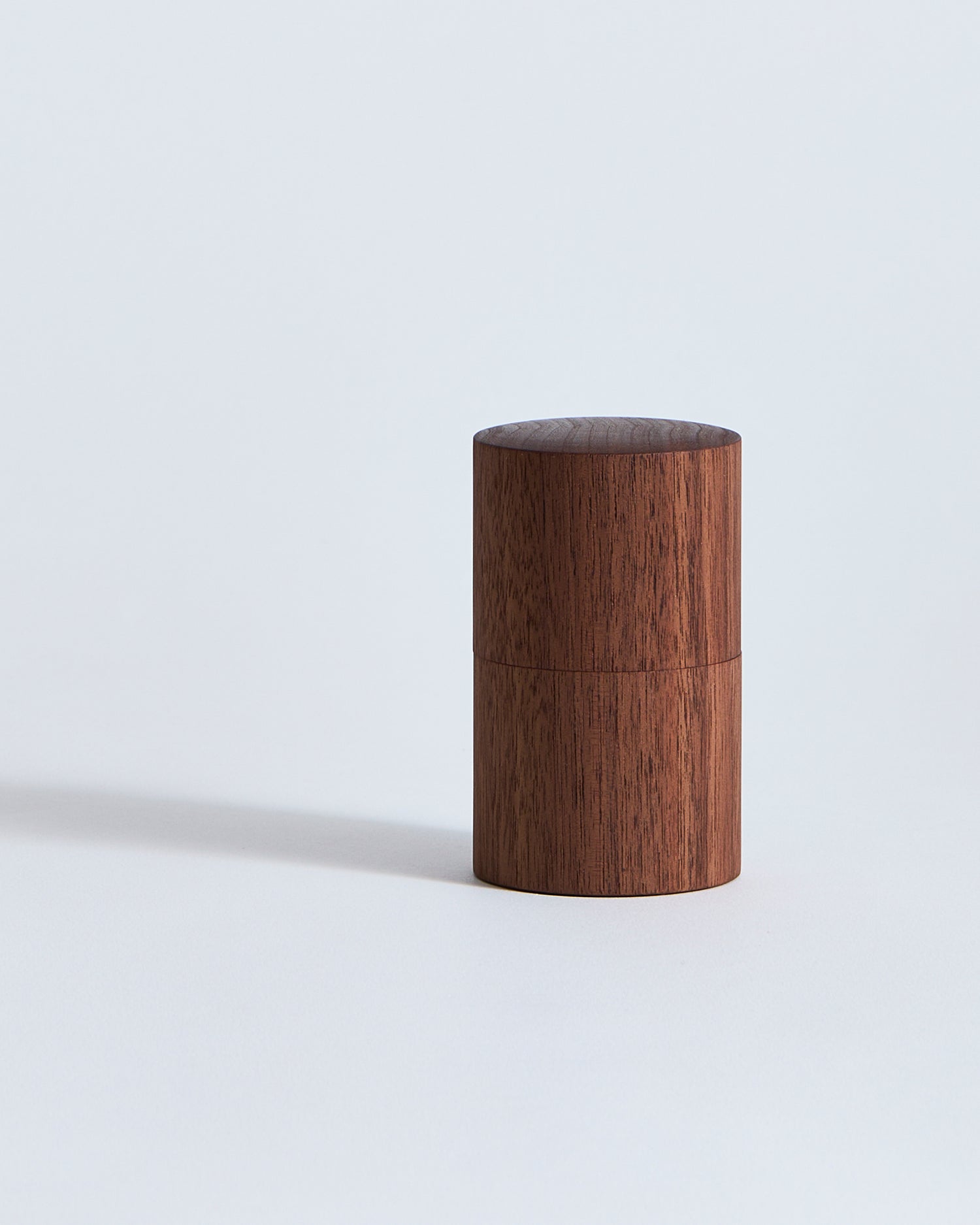 Wooden cylindrical container by Ryuiji Mitani on a light gray background
