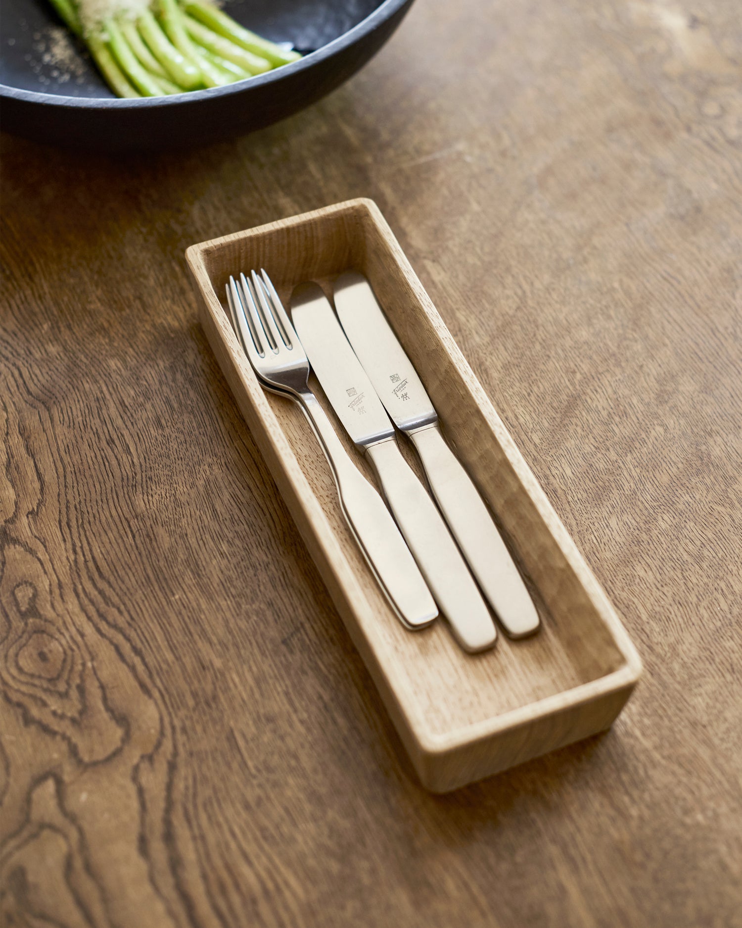 Set of cutlery in a wooden box by Ryuji Mitani  on a wooden surface