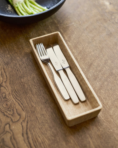 Set of cutlery in a wooden box by Ryuji Mitani  on a wooden surface