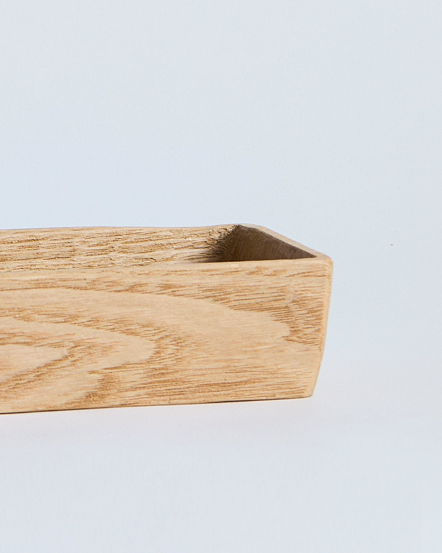 Close up of beveled edge of wooden rectangular box by Ryuji Mitani  on a light gray background