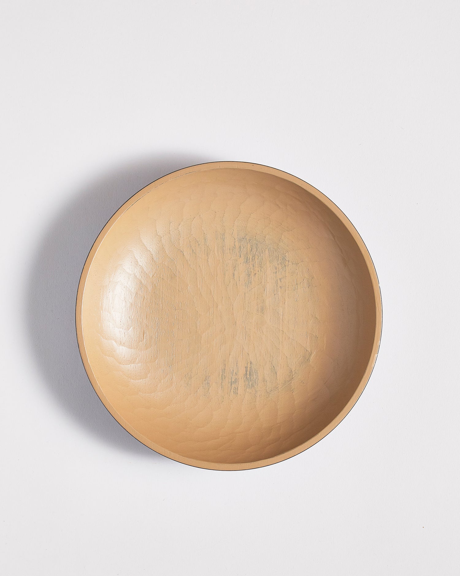 Top view of wooden bowl with beige interior by Ryuji Mitani on a light gray background