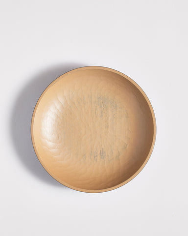 Top view of wooden bowl with beige interior by Ryuji Mitani on a light gray background