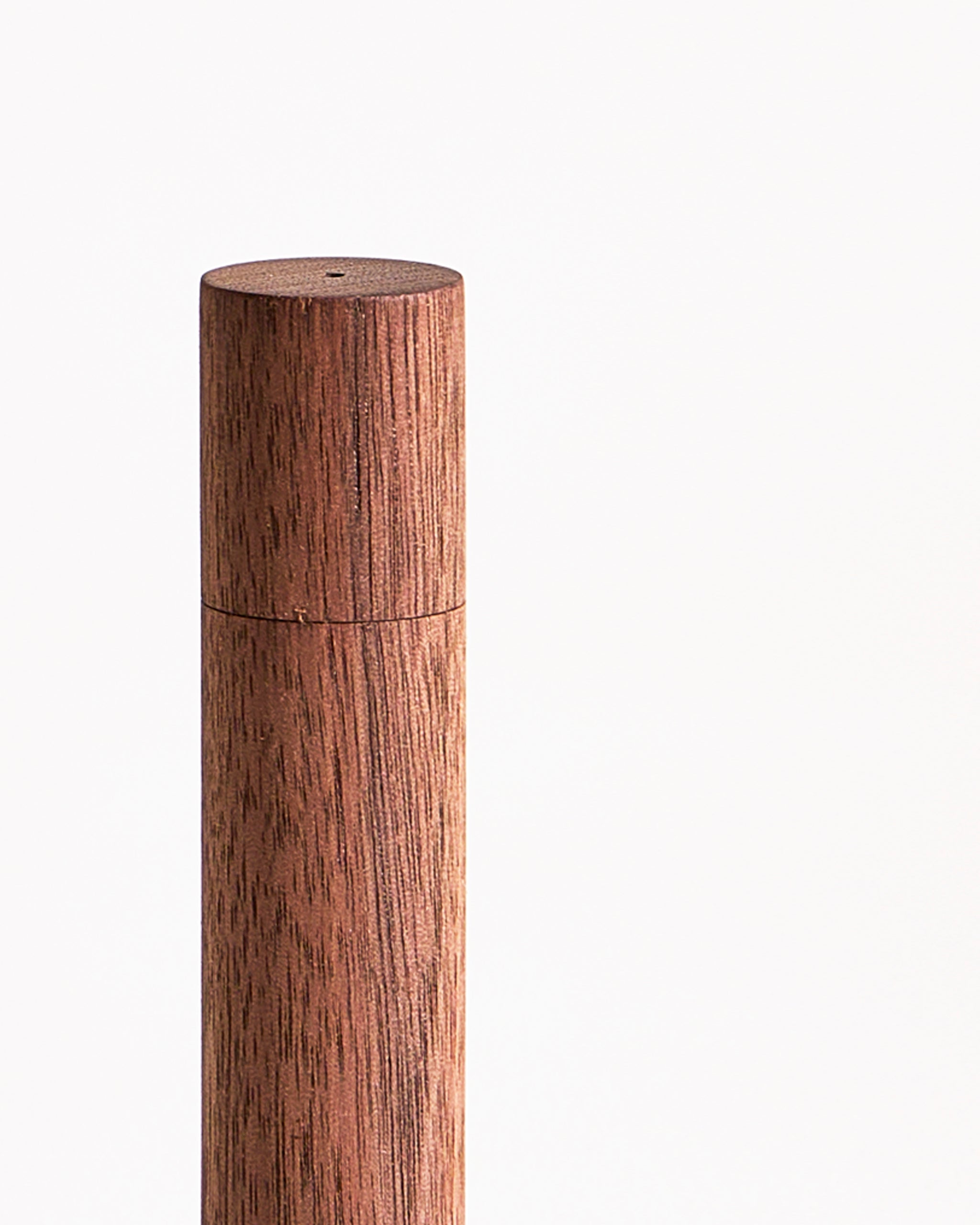 An upclose view of the top of a wooden incense case on a gray background